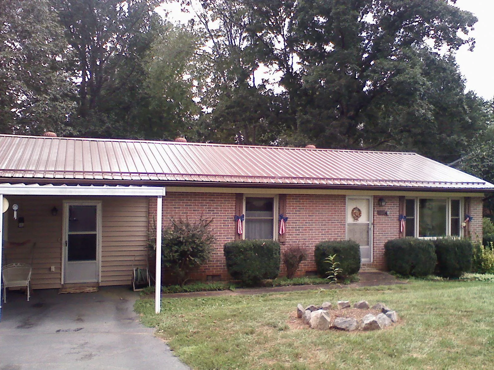 Bronze metal roof and carport on a brick ranch home — Roof Repair work by our crew in Morgantown